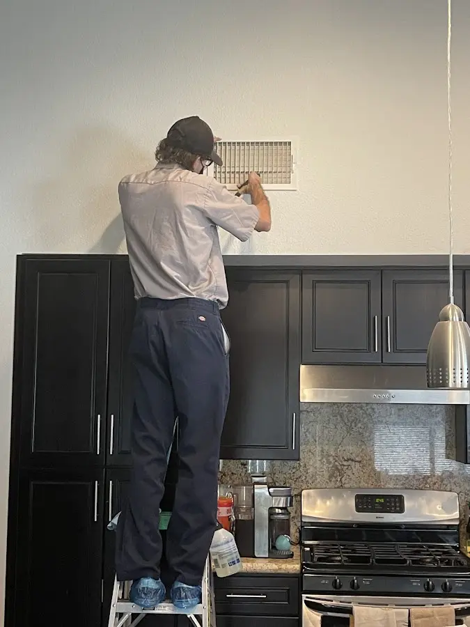 Technician inspecting an air vent during HVAC service in Savannah